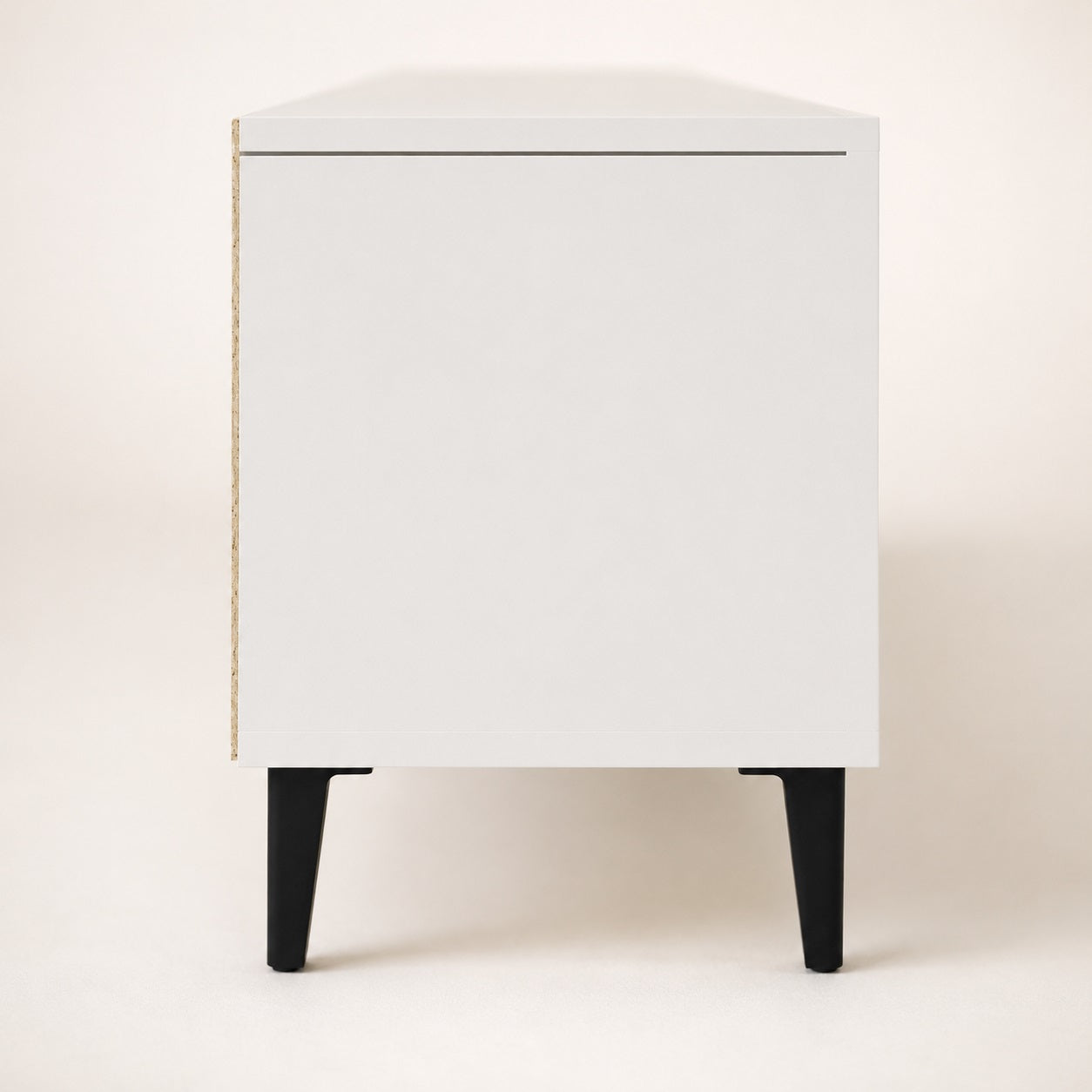 Vue latérale d’un meuble TV moderne avec rangements, finition blanche et pieds noirs design