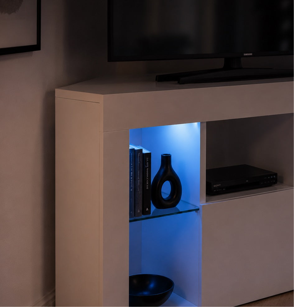 Meuble TV d'angle avec LED mettant en valeur les étagères en verre et les objets décoratifs.