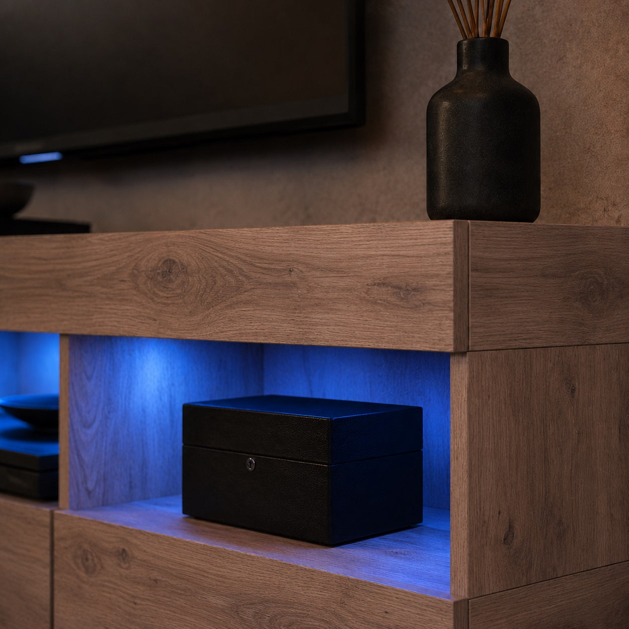 Détail rangement de meuble TV en bois suspendu avec niche ouverte et éclairage LED bleu