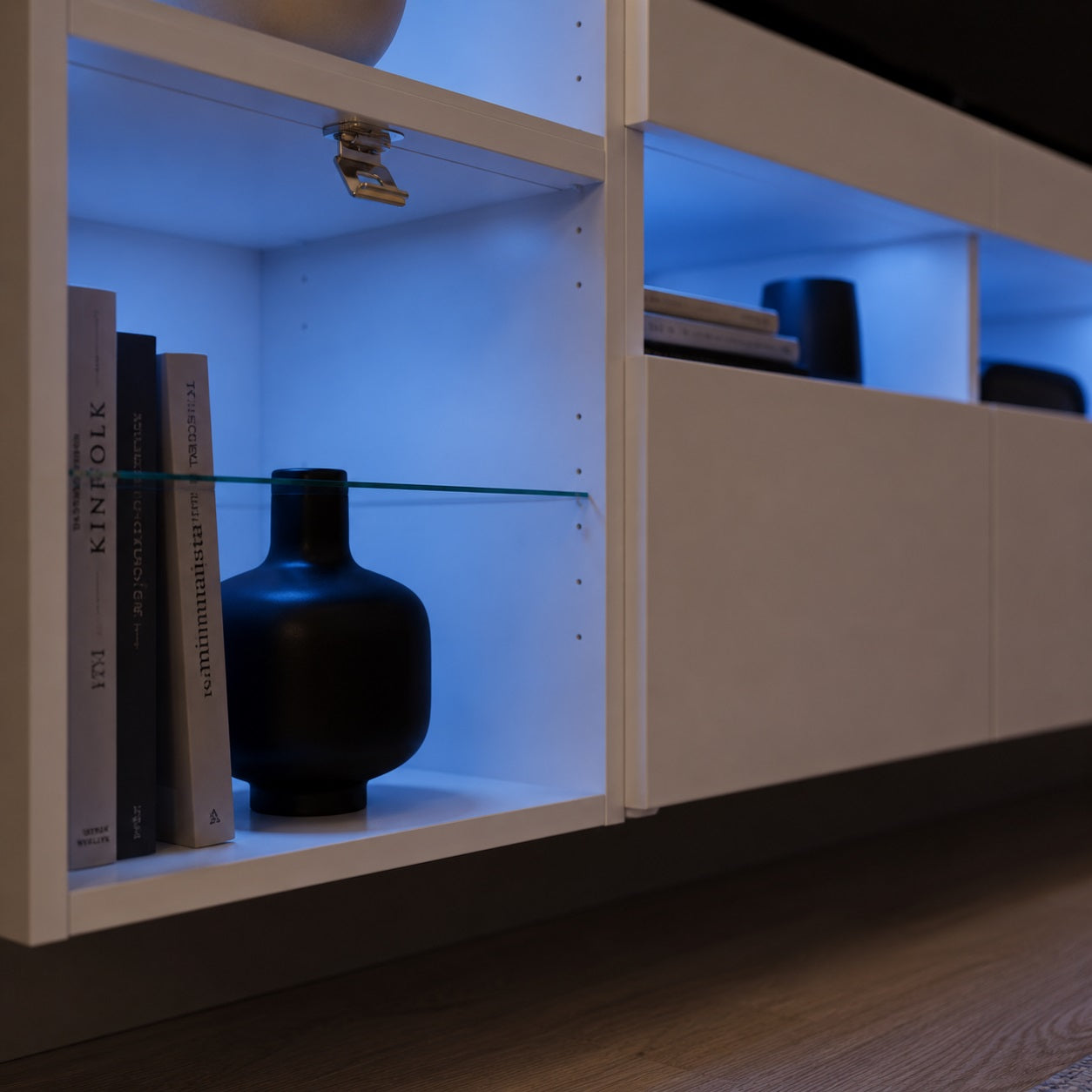 Détail meuble TV avec LED bleue et niche de rangement suspendue au design minimaliste
