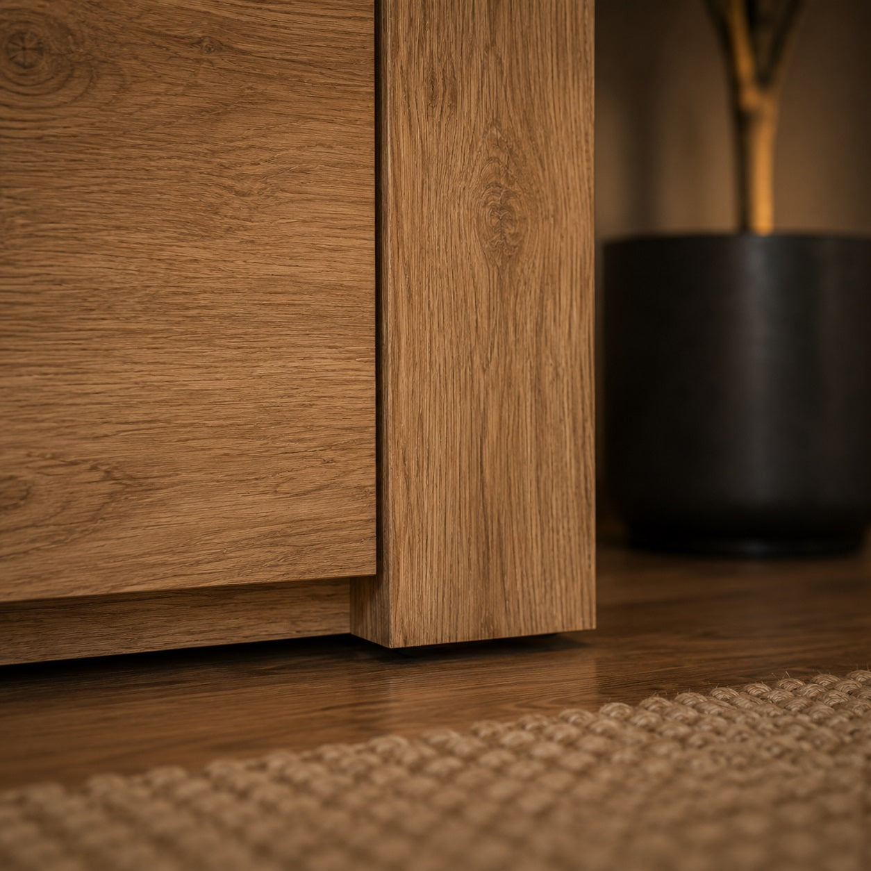 Gros plan sur le pied d’un meuble TV en bois chêne artisanal au style moderne et épuré